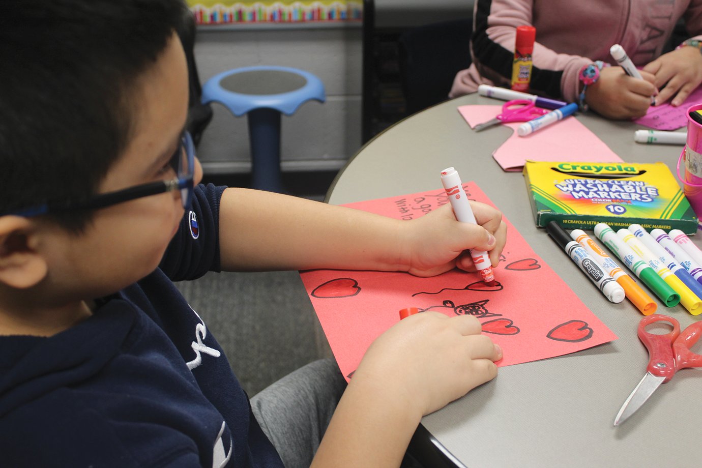 Oscar Martinez-Castellanos draws a heart balloon during class Thursday at Nicholson Elementary.